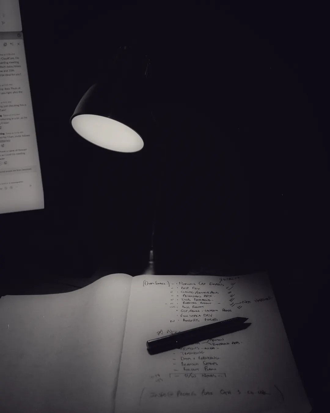Gece masa lambasının altında açık bir defter ve kalem